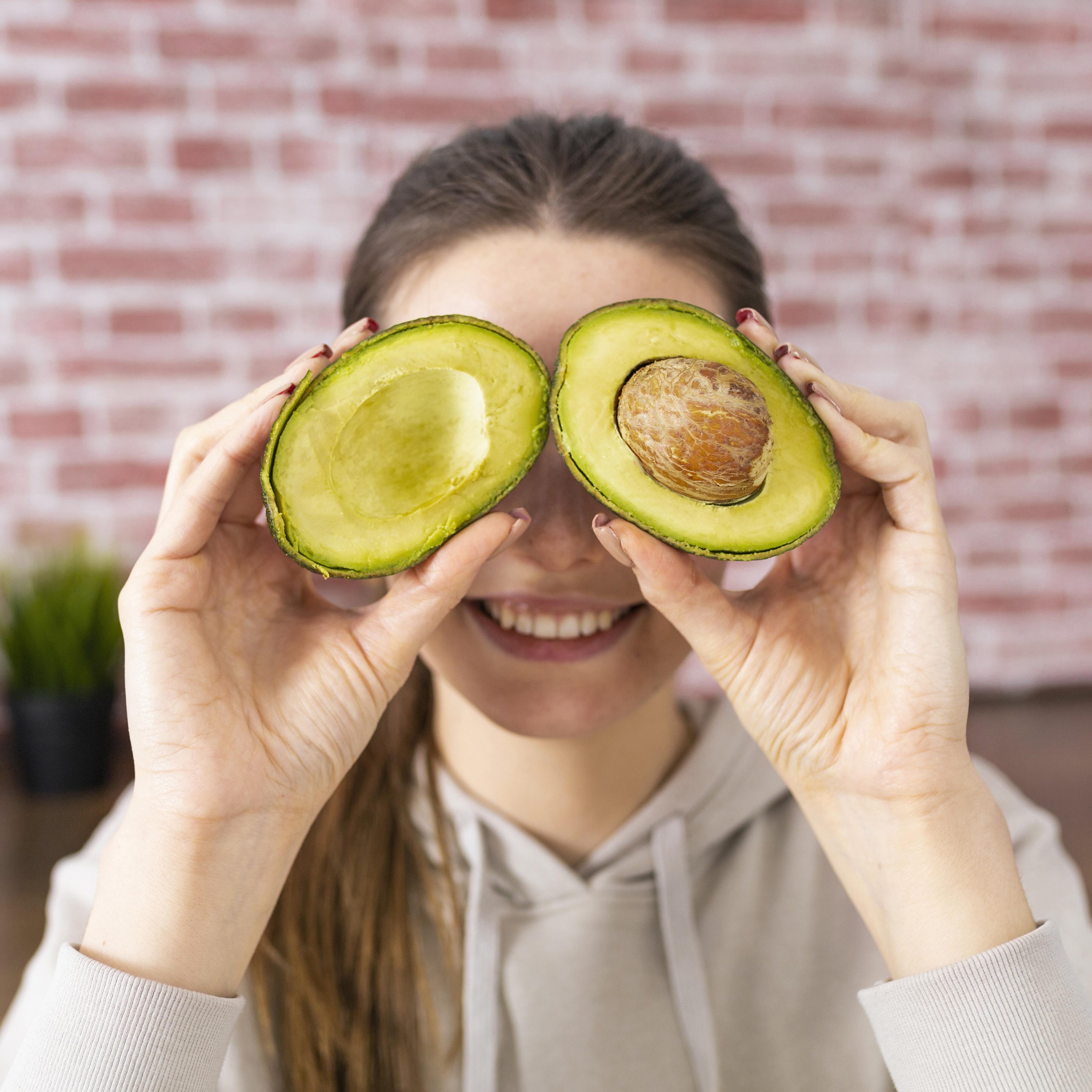 cerrar-mujer-sonriente-sosteniendo-aguacate