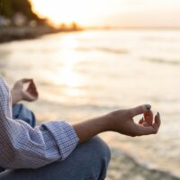 mujer-meditando-en-la-playa-con-espacio-de-copia